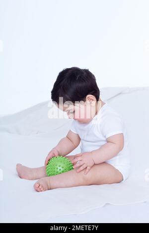 Kleines Mädchen (40 Wochen), das mit Gummiball spielt Stockfoto