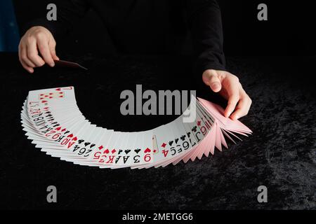 Ein Kind führt einen Kartentrick durch Stockfoto