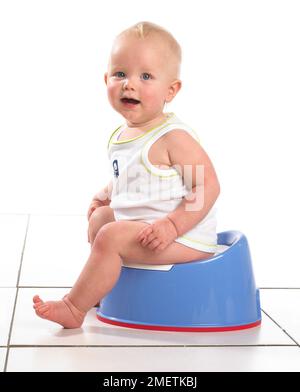Junge tragen Weste sitzen auf Blau Töpfchen, 15 Monate Stockfoto