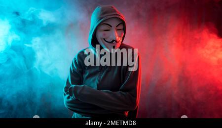 Hacker mit anonymer Maske, mit verschränkten Armen und einem bedrohlichen Blick Stockfoto