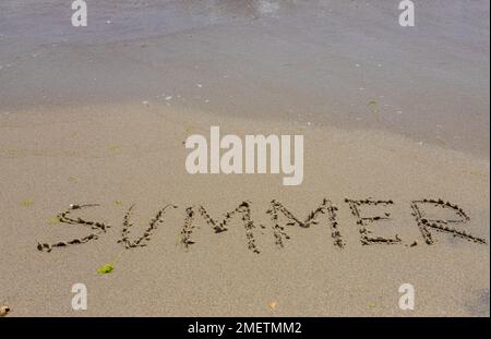 Die Inschrift auf dem Sand Summer symbolisiert einen Sommerurlaub am Meer. Stockfoto