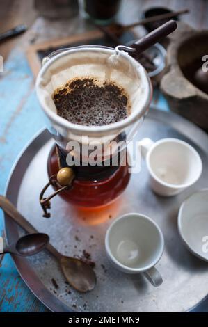 Caffe Touba, Kaffee läuft durch ein Tuch in eine Glaskanne Stockfoto