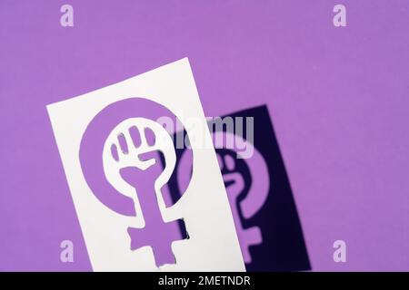 Symbol des Kampfes des Feminismus auf violettem Hintergrund, geballte Faust einer Frau bei den protesten für Frauenrechte im märz Stockfoto