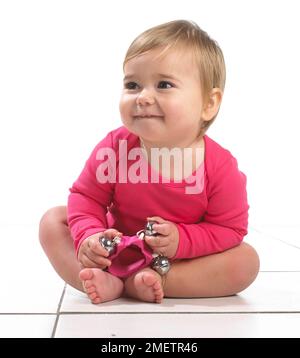 Babymädchen (12 Monate) halten Glocken Stockfoto