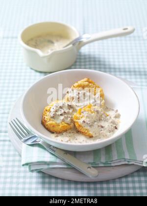 Kekse (herzhafte Scones) mit cremiger Wurstsoße Stockfoto