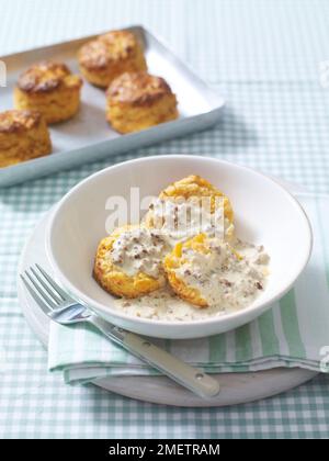 Kekse (herzhafte Scones) mit cremiger Wurstsoße Stockfoto