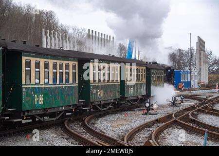 24. Januar 2023, Mecklenburg-Vorpommern, Putbus: Die Dampflokomotive 99 4632 der kleinen Eisenbahn „Rasender Roland“ fährt durch den Bahnhof in Putbus auf der Insel Rügen. Im Hintergrund wird ein neues Depot gebaut. Das Projekt „Railroad Experience Landscape“ umfasst den Bau eines neuen Schuppens und einer Betriebswerkstatt sowie einen Wasserturm für den Betrieb der Dampflokomotiven auf der Grundlage eines historischen Modells. Das Projekt „Railroad Experience Landscape“ hat ein Gesamtinvestitionsvolumen von über 40 Millionen Euro. Sie wird vom Bezirk Vorpommern-Rügen tog umgesetzt Stockfoto