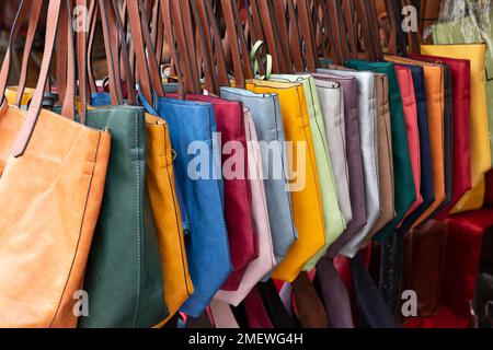 Eine Auswahl an farbenfrohen Ledertaschen zum Verkauf auf dem Markt San Lorenzo in Florenz, Italien. Stockfoto