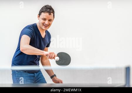 Ein Mann spielt Tischtennis im Fitnessstudio Stockfoto