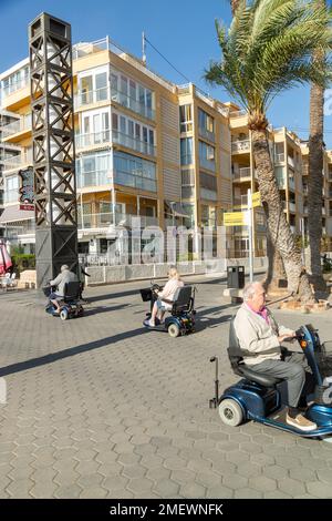 Menschen, die Mobilitätsroller auf der promenade von benidorm benutzen Stockfoto