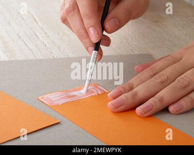 Papierhandwerk. Heimwerker-Tiermaske. Schritt 1 Hinzufügen von PVA zum Papierstreifen Stockfoto