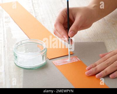 Papierhandwerk. Heimwerker-Tiermaske. Schritt 1 Hinzufügen von PVA zum Papierstreifen Stockfoto