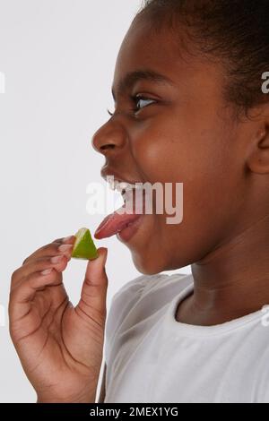 Als Teil eines Geschmackstests wird ein Keil Kalk verwendet. Modellalter 7. Stockfoto