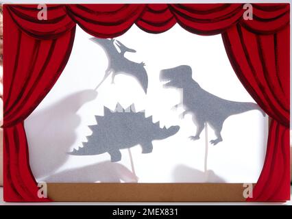 Schauspiel mit Schattenpuppen - Dinosaurierschatten mit Händen Stockfoto