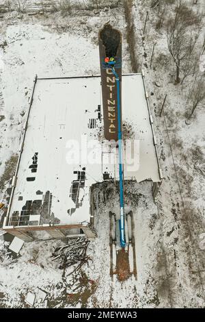 Detroit, Michigan, USA. 23. Januar 2023. Arbeiter reißen den Kamin des Kraftwerks bei Continental Motors ab. Es ist das letzte von mehreren Gebäuden, die abgerissen wurden. Das Werk stellte von 1912 bis 1955 Auto- und Flugzeugmotoren her und beschäftigte bis zu 8.000 Mitarbeiter. Kredit: Jim West/Alamy Live News Stockfoto