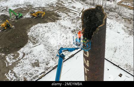 Detroit, Michigan, USA. 23. Januar 2023. Arbeiter reißen den Kamin des Kraftwerks bei Continental Motors ab. Es ist das letzte von mehreren Gebäuden, die abgerissen wurden. Das Werk stellte von 1912 bis 1955 Auto- und Flugzeugmotoren her und beschäftigte bis zu 8.000 Mitarbeiter. Kredit: Jim West/Alamy Live News Stockfoto