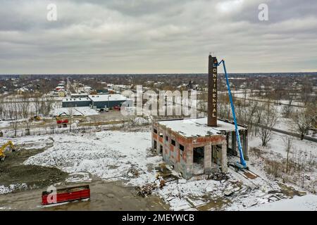 Detroit, Michigan, USA. 23. Januar 2023. Arbeiter reißen den Kamin des Kraftwerks bei Continental Motors ab. Es ist das letzte von mehreren Gebäuden, die abgerissen wurden. Das Werk stellte von 1912 bis 1955 Auto- und Flugzeugmotoren her und beschäftigte bis zu 8.000 Mitarbeiter. Kredit: Jim West/Alamy Live News Stockfoto