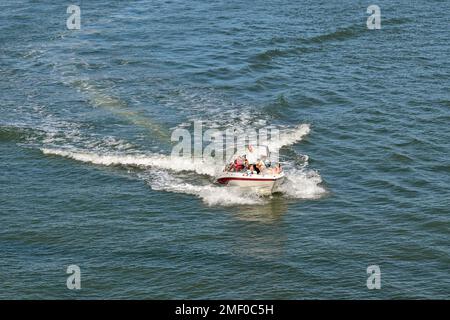 Rotterdam, Nertherland - August 2022: Menschen an Bord eines kleinen Schnellboots, das auf dem Nieuwe Maas River segelt. Stockfoto