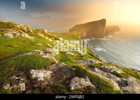 Goldenes Licht durchbricht Regenwolken am Neist Point auf der Isle of Skye, Schottland, Großbritannien. Stockfoto