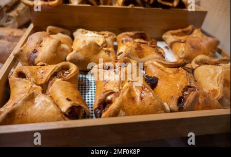 Spanische Snacks und Street Food, gebackener Kuchen Empanadilla mit verschiedenen Füllungen auf dem Markt in San-Sebastian, Spanien, aus nächster Nähe Stockfoto