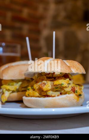 Typischer Mini-Burger-Snack aus dem Baskenland, Pinchos oder Pinxtos, kleines Stück Brot mit verschiedenen Belägen, serviert in der Bar in San-Sebastian oder Bilba Stockfoto