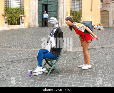 Rom, Italien, 05. Mai 2015: Ein junges Mädchen Posiert neben einem unsichtbaren Straßenmenschen, Altstadt, Roma, Italien Stockfoto