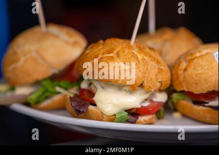 Typischer Mini-Burger-Snack aus dem Baskenland, Pinchos oder Pinxtos, kleines Stück Brot mit verschiedenen Belägen, serviert in der Bar in San-Sebastian oder Bilba Stockfoto