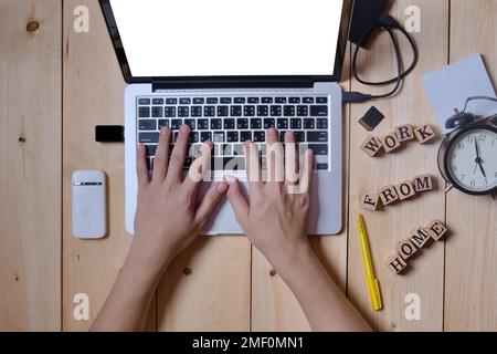 Nahaufnahme Hände Mann, der Tastatur auf Computer Laptop tragbar für die Arbeit zu Hause mit Hardware Zubehör auf Holztisch Stockfoto