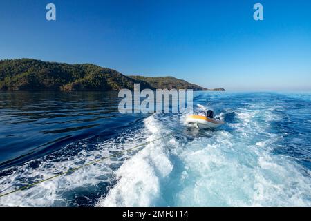 Aufblasbares Gummiboot wird in Gokova Bay, Türkei, abgeschleppt Stockfoto