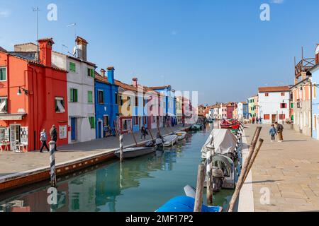 Kanal auf der Insel Burano, gesäumt von Booten und farbenfrohen Gebäuden, venezianische Lagune, Veneto, Italien. Stockfoto