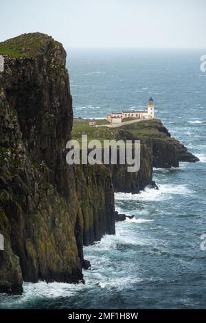 Raue Wellen stürzen auf die Klippen rund um den Neist Point Lighthouse auf der Isle of Skye, Schottland, Großbritannien.