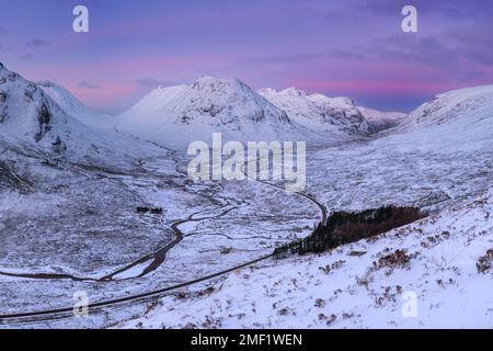 Gewundene Straße A82 führt durch das Tal von Glencoe mit wunderschöner Berglandschaft bei Sonnenaufgang. Scottish Highlands, Großbritannien. Stockfoto
