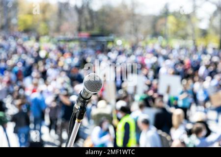 Arbeitslosenstreik, öffentliche Demonstration oder gegen die Regierung gerichteter Protest. Mikrofon im Fokus gegen unerkennbare Menge. Stockfoto