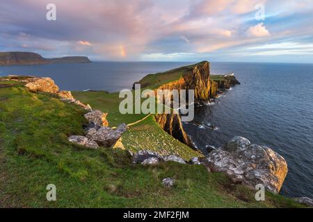 Atemberaubender Blick auf den Leuchtturm Neist Point mit Regenbogen zur Küste. Isle of Skye, Schottland, Vereinigtes Königreich. Stockfoto