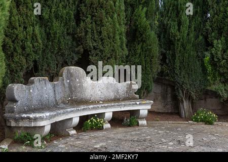 Steinbank im Garten La Foce, einem der schönsten privaten Gärten Italiens, in der toskanischen Region Val d'Orcia. Stockfoto