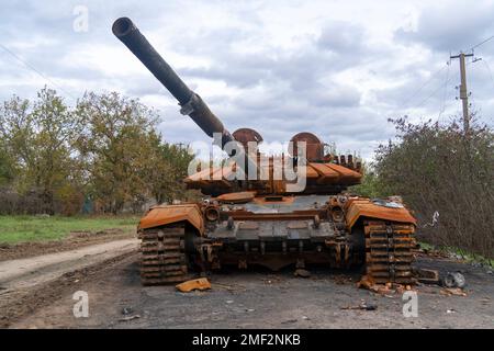 Auf dem Land nach der Schlacht. Ein zerstörter verbrannter Panzer steht auf der Straße. Krieg in der Ukraine. Russische Invasion der Ukraine Stockfoto