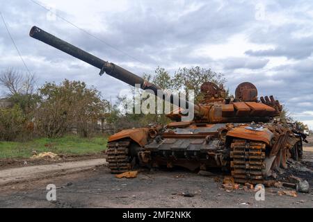 Auf dem Land nach der Schlacht. Ein zerstörter verbrannter Panzer steht auf der Straße. Krieg in der Ukraine. Russische Invasion der Ukraine Stockfoto