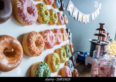 Schokoriegel mit Donuts. Tisch mit verschiedenen Süßigkeiten zur Party. Stockfoto