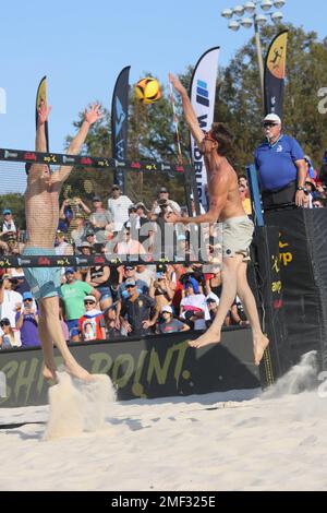 Taylor Crabb (rechts) spitzt den Ball, als Tri Bourne (links) versucht, ihn während des Herrenfinals bei den AVP Central Florida Open im Hickory POI zu blockieren Stockfoto