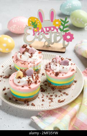 Ostern-Mini-Käsekuchen mit Zuckereiern und Schlagsahne. Stockfoto