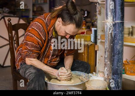 Professioneller männlicher Töpfer, der Tonbecher in der Werkstatt herstellt Stockfoto