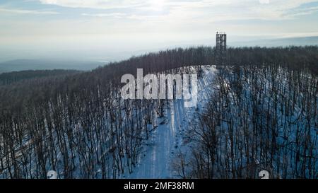 Blick aus der Vogelperspektive auf den hölzernen Aussichtsturm auf dem Gipfel des Velka Homola im Winter, Male Karpaty, Slowakei Stockfoto