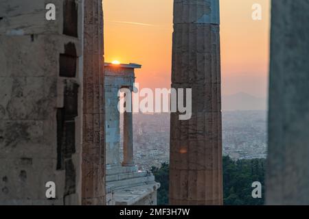 Ein Bild des Sonnenuntergangs, der durch die Ruinen von Propylaea, dem Tor zur Akropolis von Athen, und den Gipfel des Tempels der Athena N berührt Stockfoto