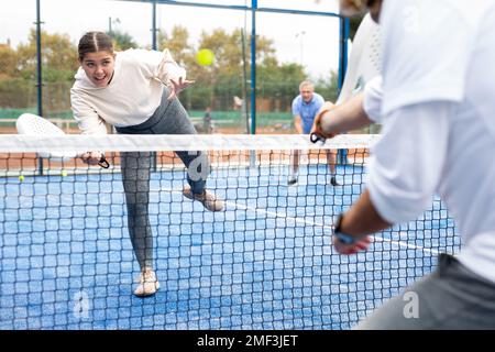 Frau, die während des Trainings auf dem Platz mit dem Padel spielt Stockfoto