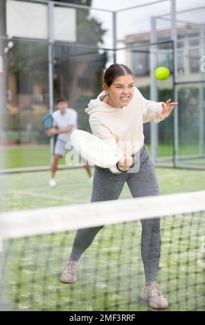 Frau, die während des Trainings auf dem Platz mit dem Padel spielt Stockfoto