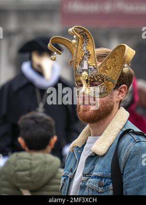 Bärtiger rothaariger Mann mittleren Alters in einer Narren-Karnevalsmaske auf dem Karneval in Venedig Stockfoto