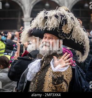 Bärtiger, grauhaariger Senior-Mann in einem großen Carnival-Tricornhut und mittelalterlichem Kostüm winkend Hand auf dem Karneval in Venedig Stockfoto