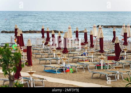 Sonnenliegen und Sonnenschirme am Strand. Stockfoto