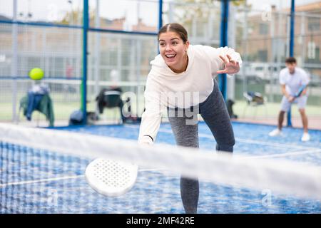 Frau, die während des Trainings auf dem Platz mit dem Padel spielt Stockfoto