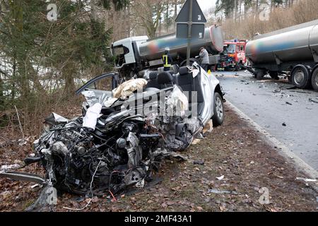 Lennestadt, Deutschland. 24. Januar 2023. Beide in den Unfall verwickelten Fahrzeuge lagen in einem Graben auf dem B55, nachdem das Fahrzeug mit einem voll beladenen Gelenkzug kollidierte. Bei dem schweren Verkehrsunfall zwischen den Dörfern Bilstein und Bonzlerhammer wurde eine Person schwer und eine leicht verletzt. Kredit: Kai Osthoff/dpa - ACHTUNG: Die Beschriftung auf Lkw wurde aus rechtlichen Gründen verpixelt/dpa/Alamy Live News Stockfoto